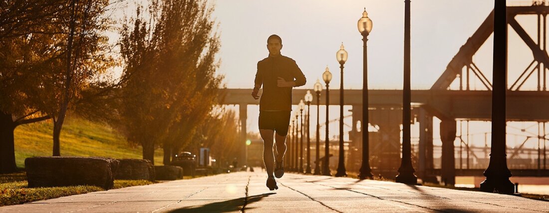 Mees jookseb m&ouml;&ouml;da teed, taustal on sild
