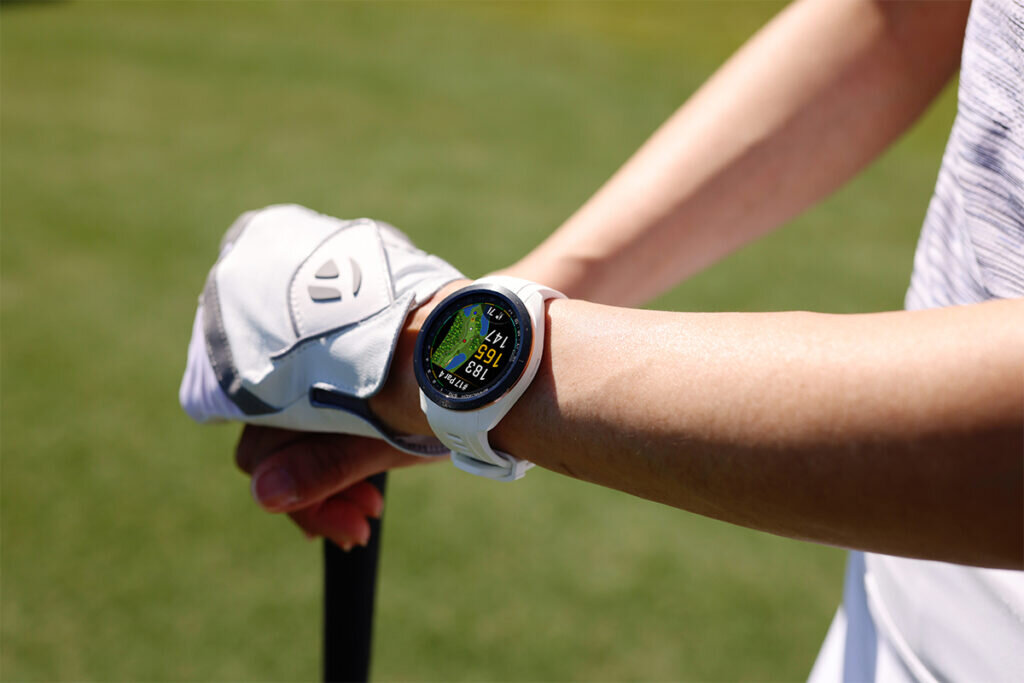 A golfer wears the Garmin Approach S70 golf smartwatch.